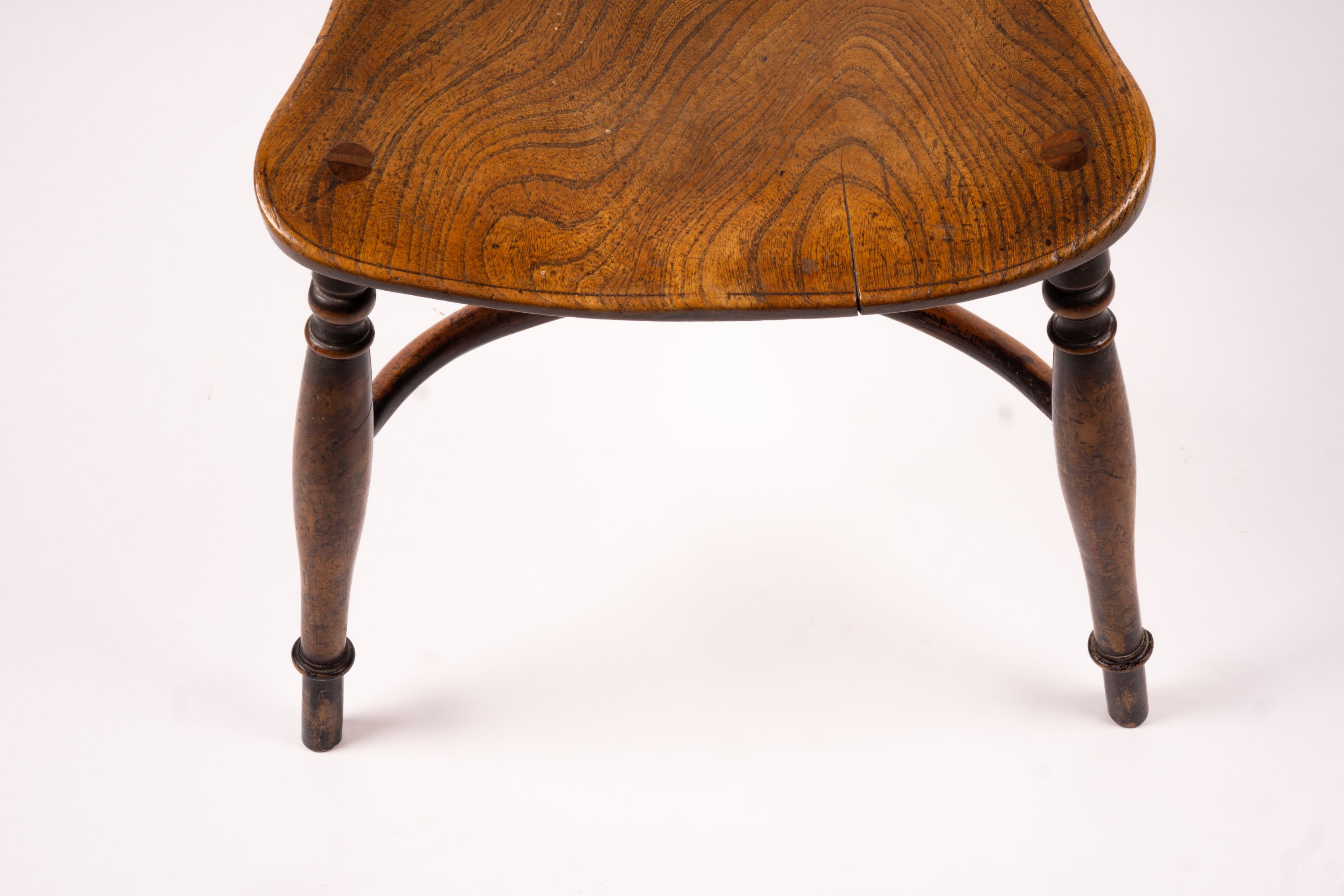 A mid 19th century ash and elm Derbyshire area Windsor elbow chair, together with a 19th century yew and elm Windsor wheel back chair with crinoline stretcher